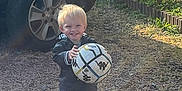 Mahé participe au concours pour gagner de l'argent avec cette photo : car, casual, child, clothing, daylight, front_view, gravel, greenery, happy, nature, outdoor, person, plants, play, shoes, smile, soccer_ball, toddler, wheel, young_child