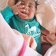 Naomi joined the competition — help win amazing prizes! baby, infant, smiling, blanket, pink, teal_clothing, unicorn_print, hand, face, cute, cozy, wrapped, happy, child, newborn, soft, sleeping_area, comfort, indoors, portrait