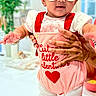 Aryahi joined the competition — help win amazing prizes! baby, bow, child, cute, fashion, footwear, hands, headband, holding, home_decor, indoor, infant, person, pink_outfit, plant, red_heart, smiling, standing, sunglasses, white_background