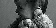 Loan participe au concours pour gagner de l'argent avec cette photo : affection, black_and_white, child, cozy, cute, face, hair, hand, happy, hugging, indoor, person, portrait, smile, soft_lighting, sweater, teddy_bear, toy, warm, young