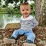 Loan participe au concours pour gagner de l'argent avec cette photo : blue_jeans, casual_clothing, child, daylight, grass, greenery, happy, lake, leaves, nature, outdoor, portrait, rock, shoes, sitting, smiling, striped_shirt, toddler, tree, water