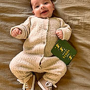 Maë a rejoint le concours — aidez-le/la à gagner de superbes lots ! baby, infant, smiling, cozy_clothing, knitwear, shoes, lying_down, blanket, card, age_marker, happy, cute, child, portrait, indoors, soft_texture, buttoned_outfit, small_hands, feet, casual