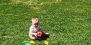 Aaron joined the competition — help win amazing prizes! baby, blue_sky, child, daytime, grass, green_bucket, happy, lawn, nature, outdoor, park, person, plastic_toys, playing, recreation, shovel, sitting, sky, sunny, water