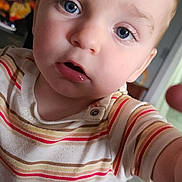 Aaron is registered to the contest to win money with this photo: toddler, child, face, blue_eyes, striped_shirt, indoor, curious, closeup, person, baby, expression, skin, hair, young_child, portrait, candid, reaching_hand, soft_light, home, casual