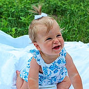 Kinsley joined the competition — help win amazing prizes! baby, child, girl, smiling, blue_bow, floral_dress, white_blanket, grass, outdoor, nature, happy, cute, sitting, infant, portrait, playful, person, summer, greenery, toddler
