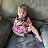 toddler, child, headphones, couch, pink_clothing, sitting, curious_expression, indoor, sparkly_shoes, baby, furniture, person, young_child, cute, casual, home, small_child, hands, face, seated