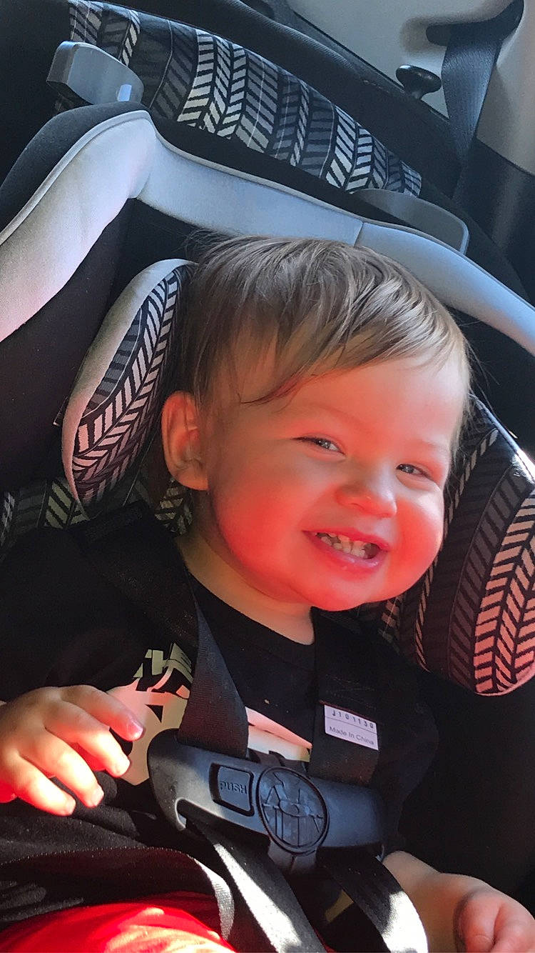 Brycen is registered to the contest to win money with this photo: auto_part, automotive_design, automotive_exterior, automotive_wheel_system, baby_carriage, blond, car_seat, car_seat_cover, child, cool, family_car, finger, flash_photography, joy, motor_vehicle, person, personal_luxury_car, smile, steering_part, steering_wheel