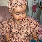 Inaya participe au concours pour gagner de l'argent avec cette photo : toddler, child, pink_clothing, bonnet, plush_toy, indoor, bed, blanket, patterned_clothing, heart_pattern, bow_pattern, cute, baby, soft_toy, mobile, sleeping_area, portrait, person, infant, young_child