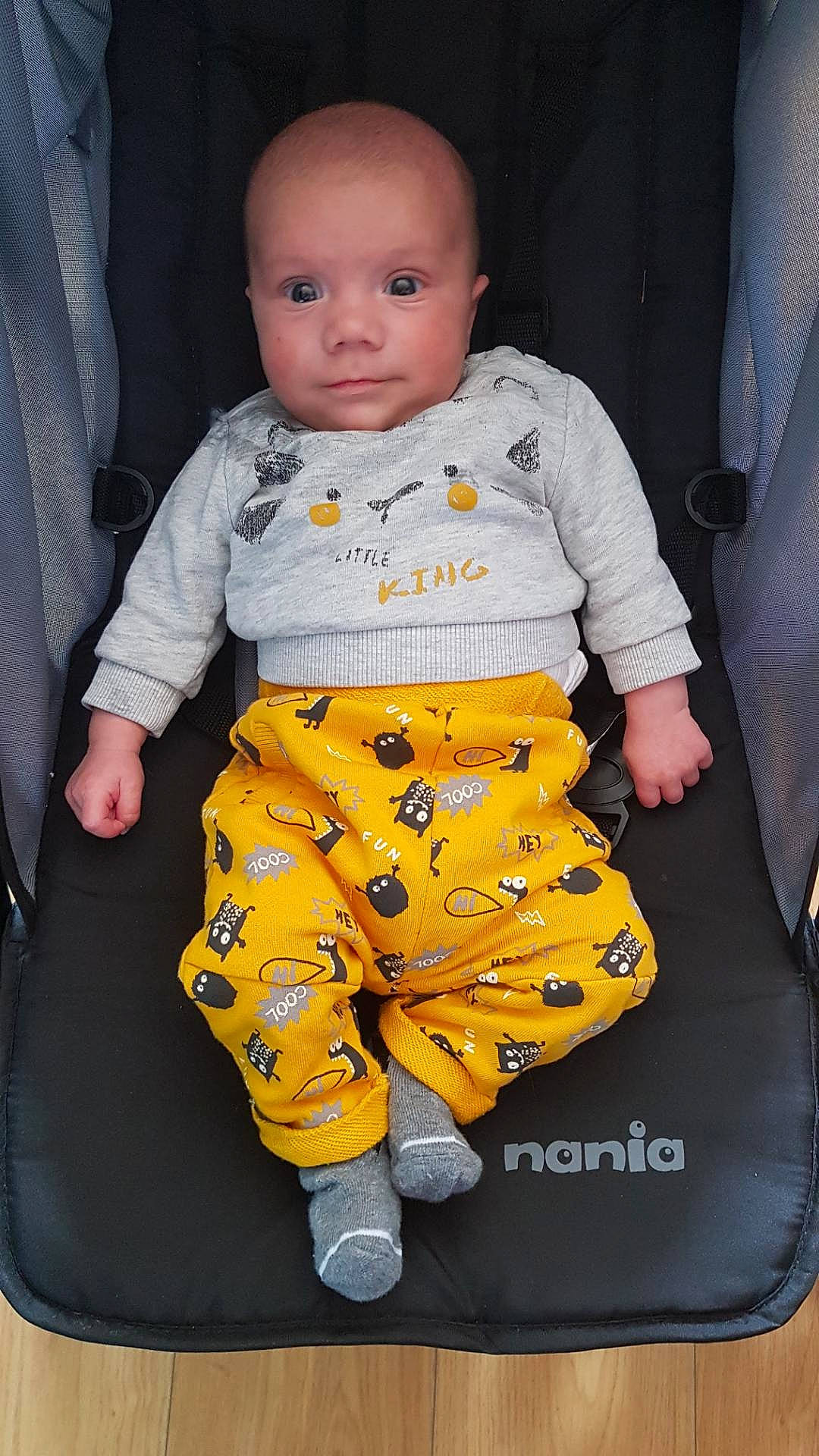 Sasha a rejoint le concours — aidez-le/la à gagner de superbes lots ! baby, baby_products, baby_toddler_clothing, child, collar, comfort, flooring, long_sleeved_t_shirt, pattern, person, sitting, sleeve, t_shirt, toddler, uniform