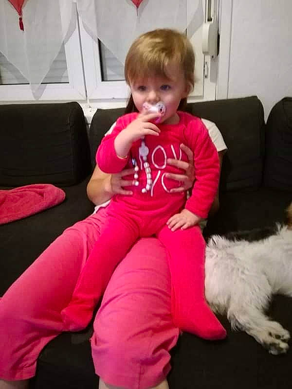 Clara participe au concours pour gagner de l'argent avec cette photo : abdomen, arm, carnivoran, child, day, ear, finger, fun, girl, joint, leg, person, pink, play, product, red, sitting, skin, textile, toddler