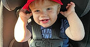 Berkley is registered to the contest to win money with this photo: toddler, child, car_seat, red_hat, bass_pro_shops, smiling, seatbelt, sunlight, blue_shirt, safety_harness, baby, cute, happy, infant, portrait, inside_car, seat, hands, face, young_child