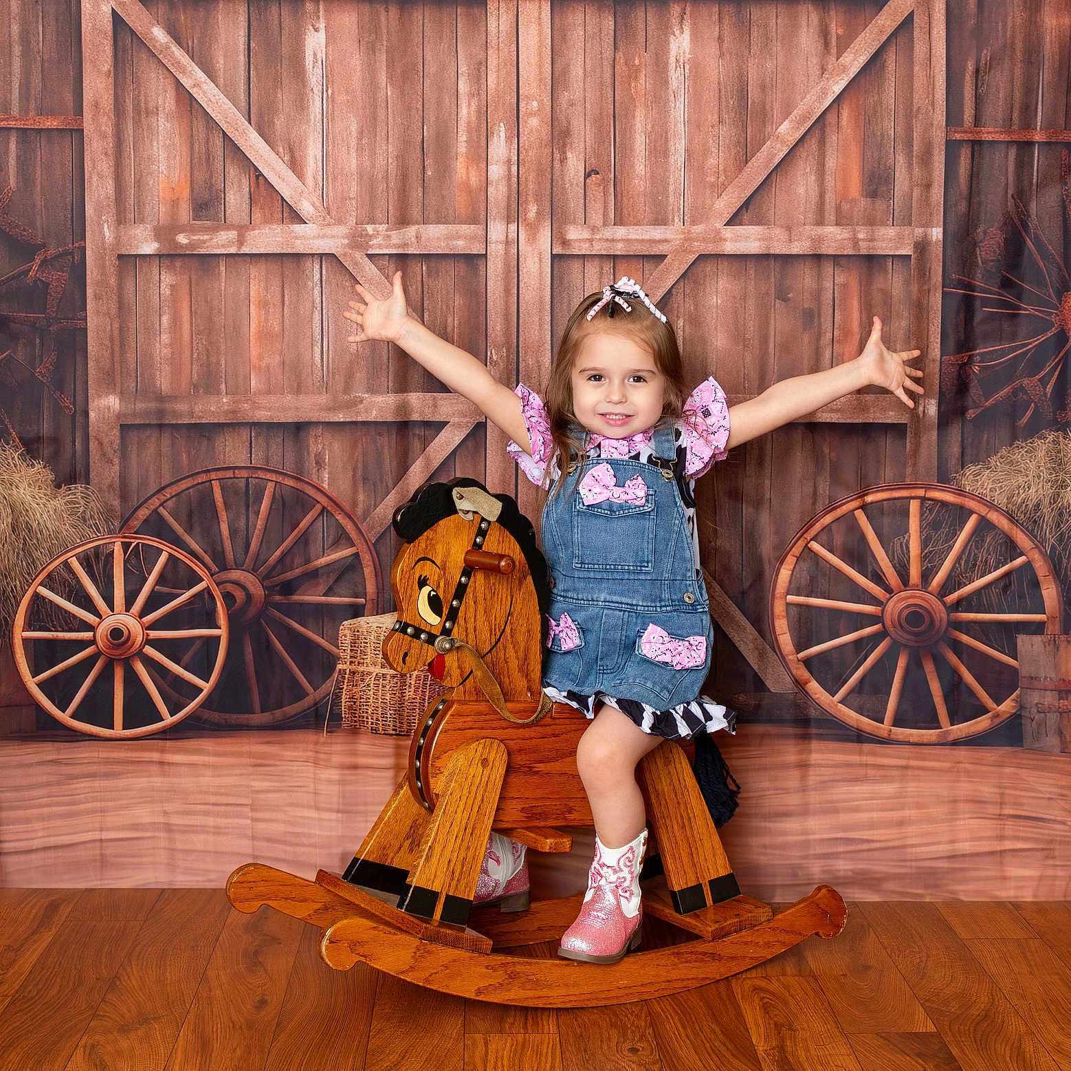 Dreamiee is registered to the contest to win money with this photo: child, girl, smiling, rocking_horse, wooden_floor, barn_backdrop, denim_dress, pink_bows, cowboy_boots, happy, arms_outstretched, playful, indoor, portrait, toy, wooden_wheels, rustic, flooring, cute, posing