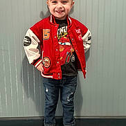 Dreamiee is registered to the contest to win money with this photo: child, smiling, standing, red_jacket, jeans, sneakers, cartoon_tshirt, hair_buns, hair_accessories, indoor, confident_pose, wall, carpet, casual_clothing, happy, portrait, person, fashion, cute, young