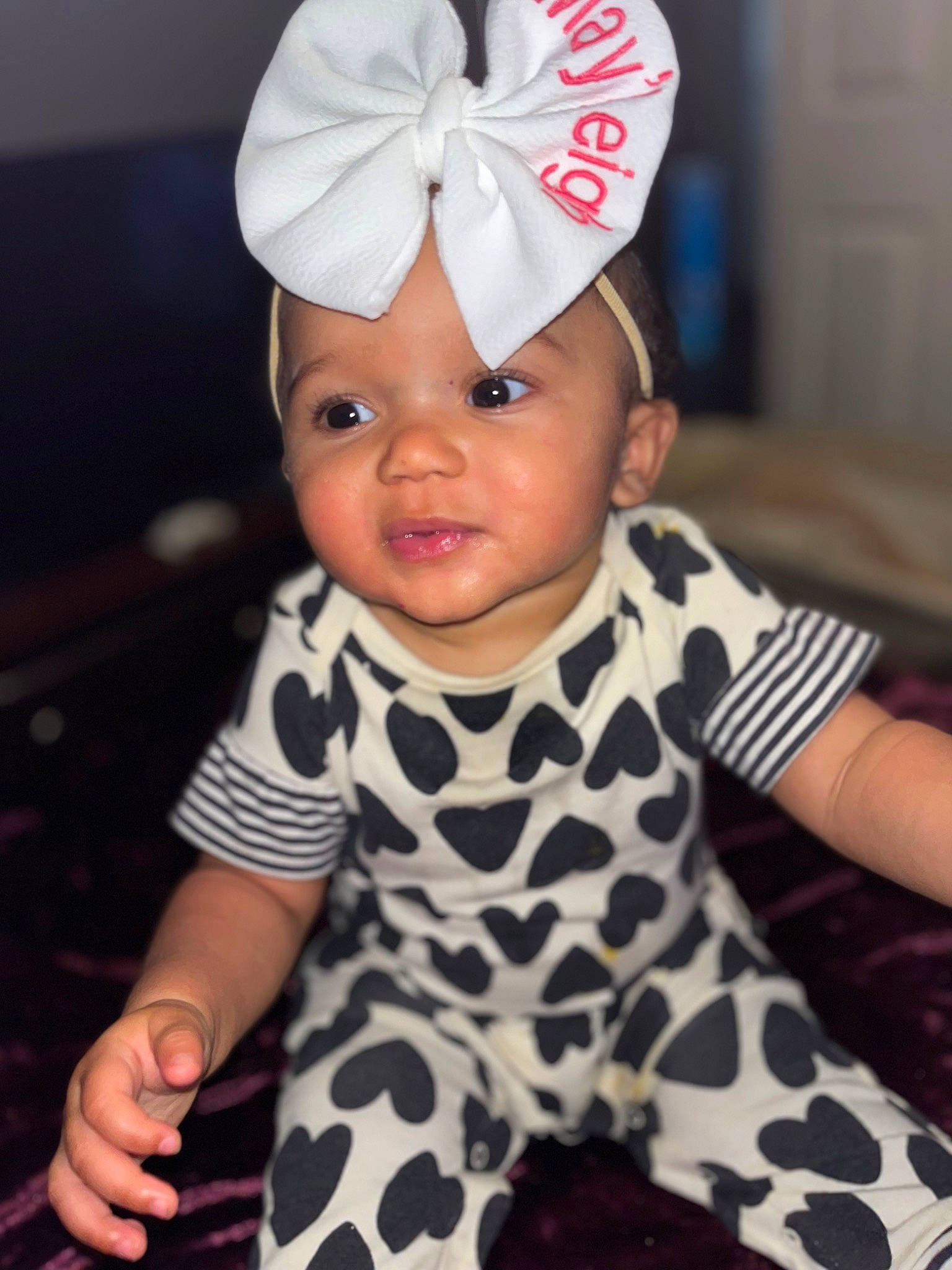 Mayleigh is registered to the contest to win money with this photo: baby, baby_toddler_clothing, black, cap, child, costume_hat, face, happy, head, headband, headgear, headpiece, headwear, pattern, person, pink, sitting, skin, sleeve, thumb