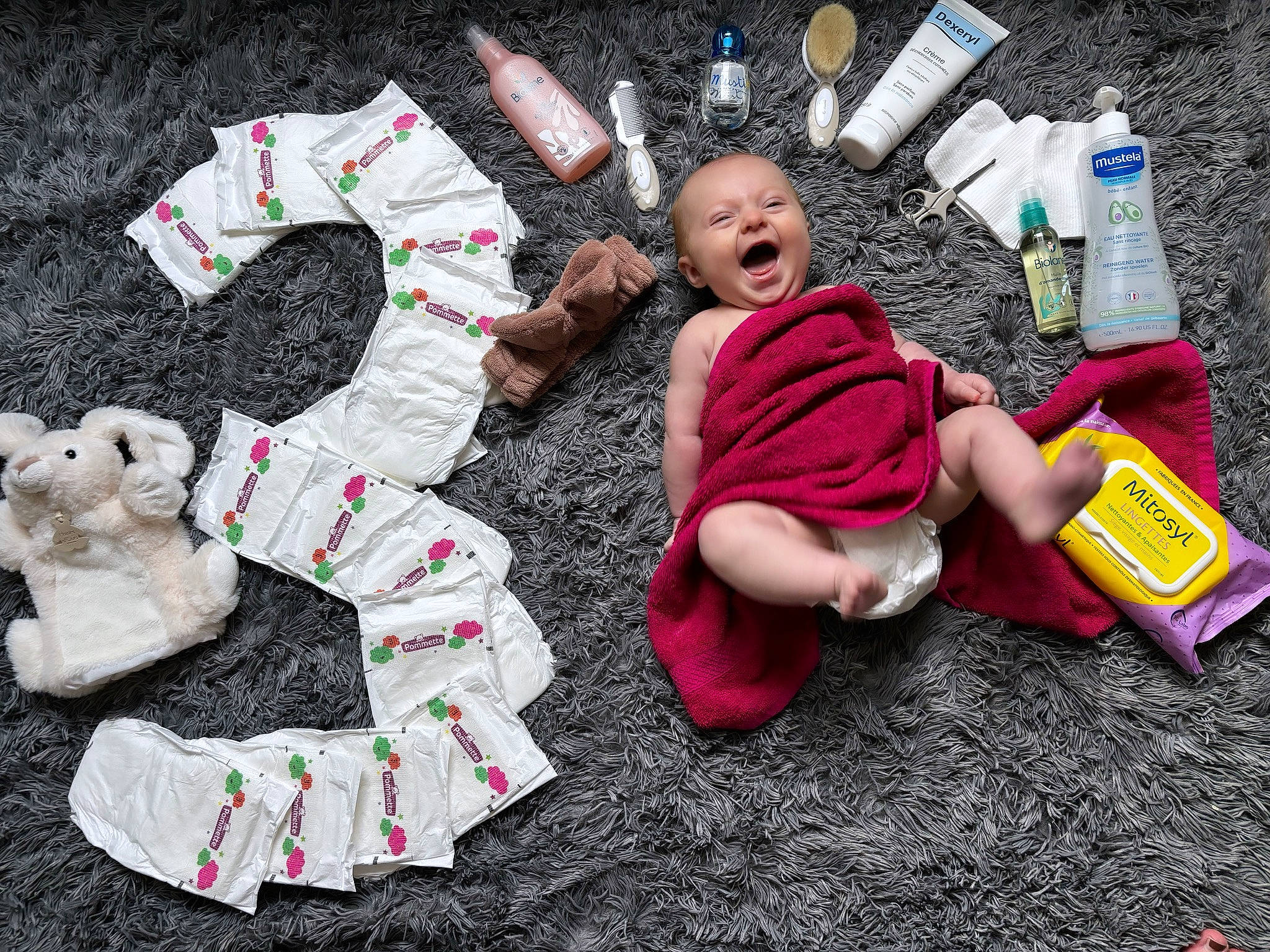 Enola participe au concours pour gagner de l'argent avec cette photo : baby_toddler_clothing, bottle, carmine, child, flooring, fun, fur, grass, leisure, linens, pattern, person, pink, plastic_bottle, play, product, sitting, sleeve, t_shirt, toddler