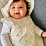 Avleen Kaur Gill joined the competition — help win amazing prizes! baby, infant, child, hat, white_clothing, floral_pattern, bracelet, couch, smile, happy, cute, indoors, portrait, face, skin, hand, sitting, cozy, fabric, closeup