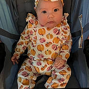 Tabitha is registered to the contest to win money with this photo: baby, infant, child, pumpkin_pattern, headband, stroller, clothing, cute, portrait, sitting, autumn, fall, orange, pink, face, eyes, hand, comfortable, indoors, young