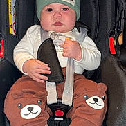 Giovanni a rejoint le concours — aidez-le/la à gagner de superbes lots ! baby, child, car_seat, beanie, hat, clothing, pants, bear_design, socks, straps, seat_belt, infant, cute, indoor, person, face, hands, footwear, expression, safety