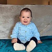 Giovanni a rejoint le concours — aidez-le/la à gagner de superbes lots ! baby, child, smiling, sitting, blue_shirt, white_socks, blanket, couch, indoor, portrait, happy, cute, person, infant, young_child, cozy, soft_lighting, furniture, casual_clothing, home
