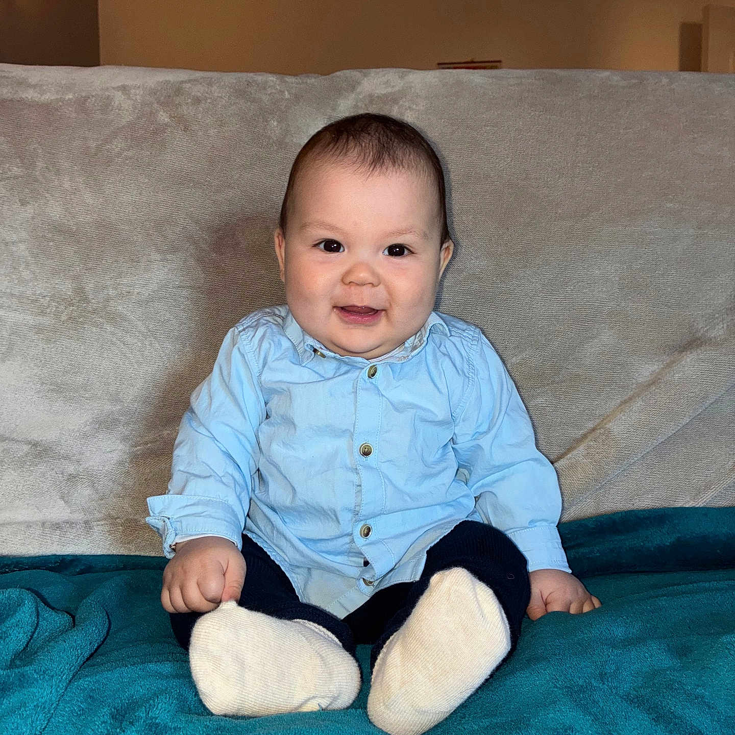 Giovanni a rejoint le concours — aidez-le/la à gagner de superbes lots ! baby, child, smiling, sitting, blue_shirt, white_socks, blanket, couch, indoor, portrait, happy, cute, person, infant, young_child, cozy, soft_lighting, furniture, casual_clothing, home