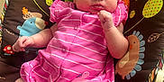 Christina is registered to the contest to win money with this photo: baby, infant, pink_clothing, striped, baby_seat, colorful, animal_pattern, tree_pattern, pout, curious, indoor, toddler, child, seat_belt, furniture, playful, comfort, portrait, person, closeup