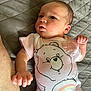 Christina joined the competition — help win amazing prizes! baby, infant, onesie, bear_graphic, rainbow, quilted_bedspread, lying_down, curious_expression, human_arm, skin, cute, child, newborn, clothing, indoors, portrait, soft_lighting, casual, relaxed, small_hand
