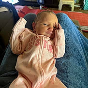 Alana is registered to the contest to win money with this photo: baby, newborn, infant, pink_sleeper, little_sister, blanket, indoor, plush_toy, blue_blanket, furniture, curious, face, person, resting, cozy, hand, child, soft_lighting, casual, relaxed