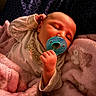 Oakleigh is registered to the contest to win money with this photo: baby, pacifier, blanket, sleeping, infant, soft_texture, clothing, hand, face, portrait, cute, child, newborn, resting, indoors, cozy, pink, blue, patterned_background, peaceful