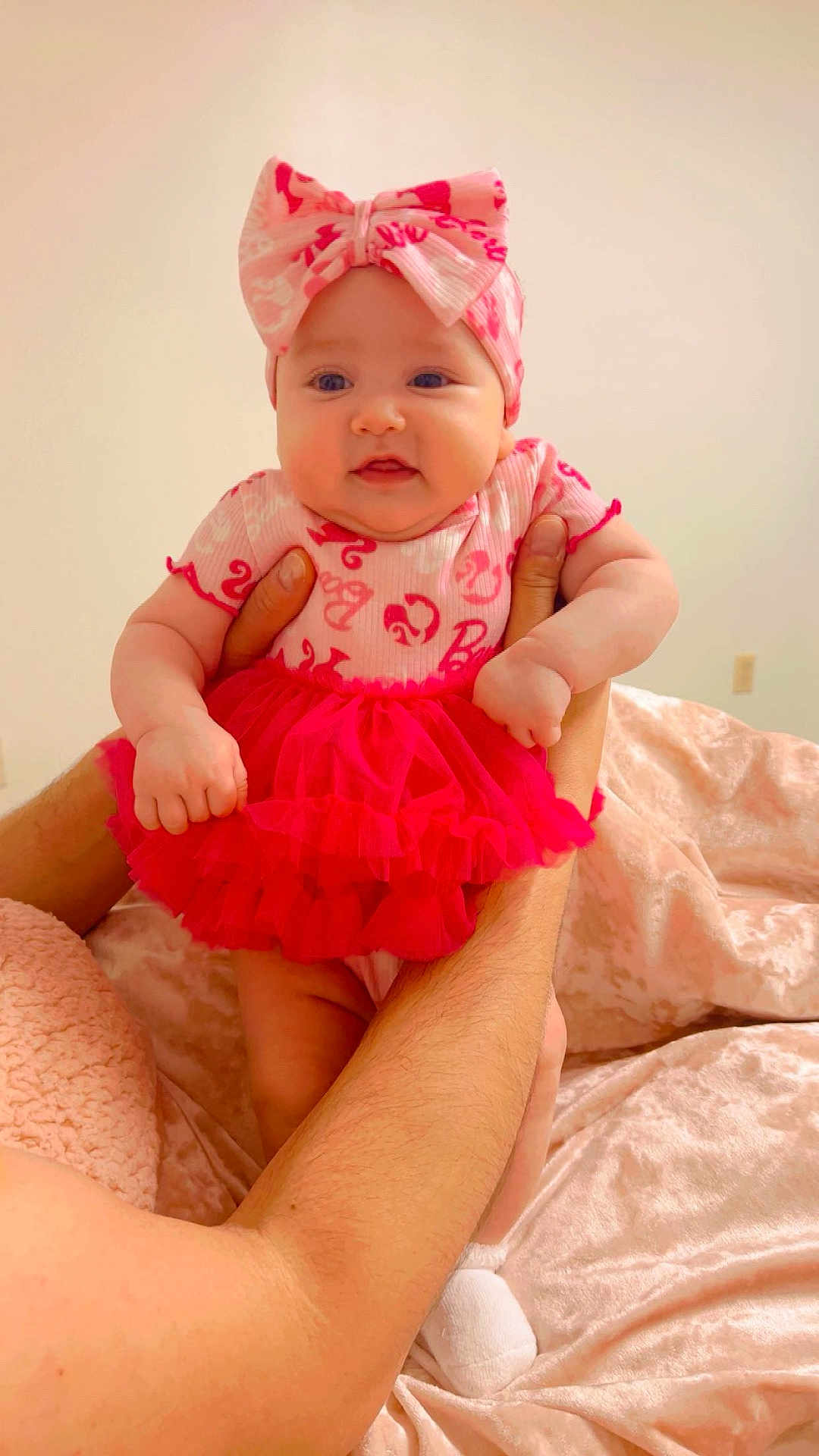 Maria is registered to the contest to win money with this photo: baby, child, infant, pink_clothing, headband, bow, tutu, arms, hands, blanket, soft_texture, indoor, person, cute, adorable, smile, skin, face, legs, sock