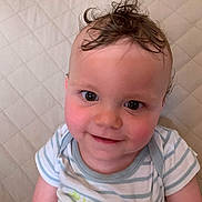 Raphael a rejoint le concours — aidez-le/la à gagner de superbes lots ! baby, cheeks, child, close_up, curly_hair, cute, eyes, face, happy, indoors, infant, onesie, person, portrait, quilted_background, skin, smiling, striped_clothing, toy, wooden_toy