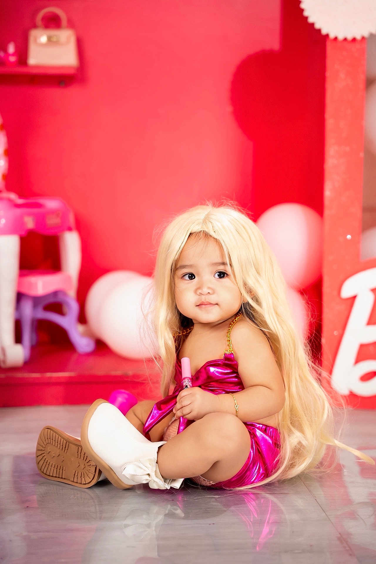 Zanayah is registered to the contest to win money with this photo: accessory, balloons, blonde_wig, child, colorful, curious, cute, fashion, floor, indoor, person, pink_outfit, playful, portrait, sitting, smile, toddler, toy, white_boots, young_child