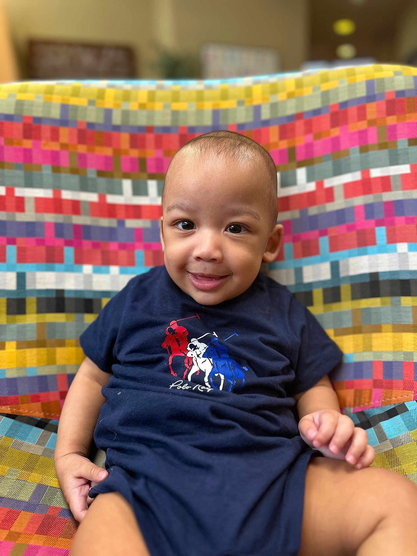 Zyaire is registered to the contest to win money with this photo: baby, child, smiling, face, person, clothing, toddler, indoor, patterned_fabric, colorful, seat, cute, happy, portrait, apparel, sitting, one_piece, young_child, infant, casual