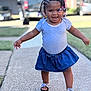 Symphoni joined the competition — help win amazing prizes! toddler, child, smiling, walking, outdoor, sidewalk, blue_skirt, braided_hair, beads, sandals, happy, person, daylight, grass, car, background_blur, casual_clothing, young_child, portrait, cute