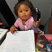 Symphoni joined the competition — help win amazing prizes! toddler, child, computer_mouse, desk, papers, notebook, office, curly_hair, pink_shirt, earrings, black_chair, writing, hand, indoor, young_child, paperclip, mouse_pad, wooden_table, expression, person