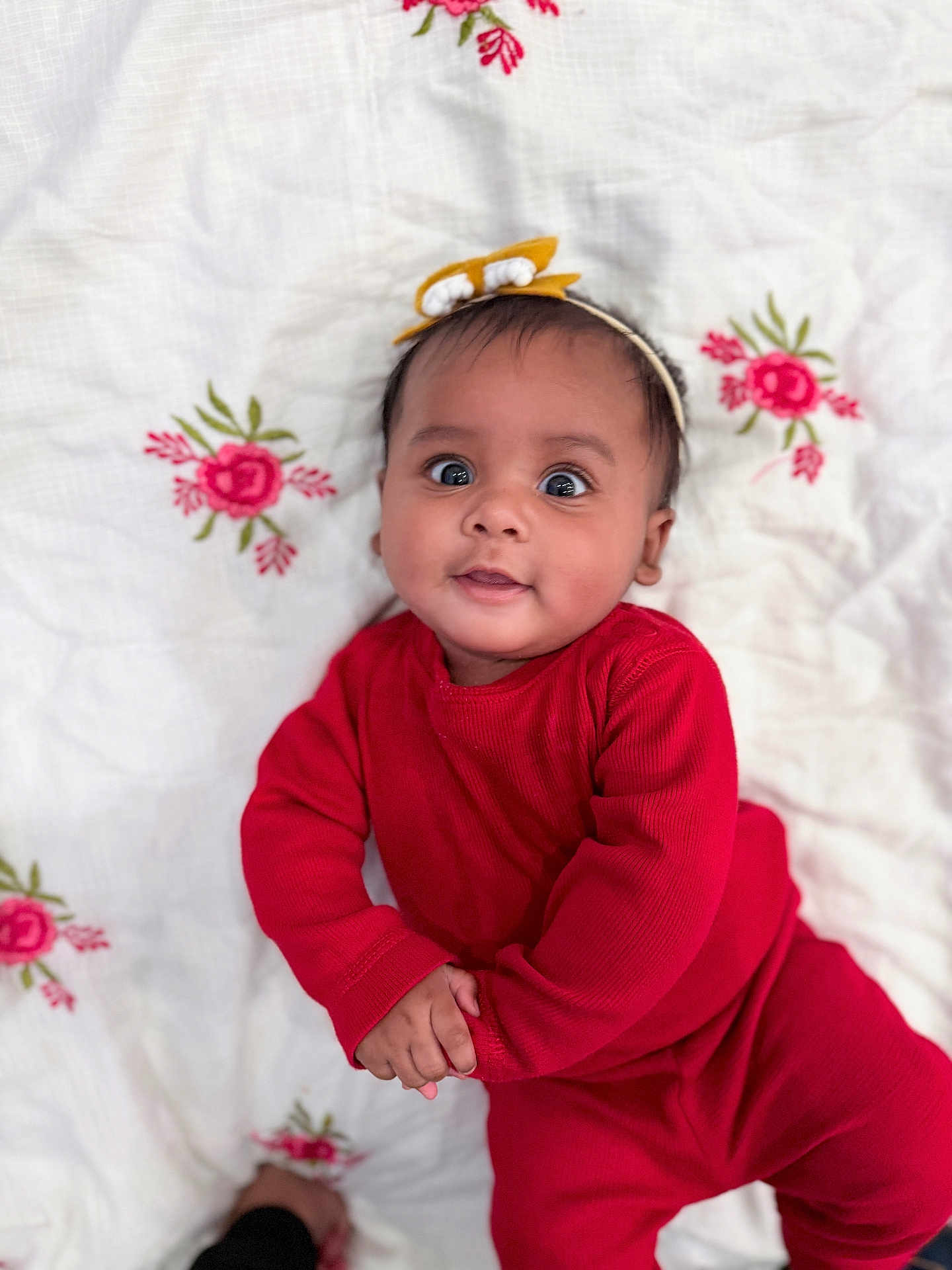 Sohalia joined the competition — help win amazing prizes! baby, infant, child, red_clothing, headband, yellow_bow, blanket, embroidered, flowers, pink_flowers, lying_down, cute, portrait, indoors, smile, wide_eyes, hand_holding, skin, face, person