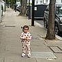 toddler, child, sidewalk, street, trees, cars, urban, buildings, clothing, footwear, person, hairclip, pavement, daytime, outdoor, curious, standing, matching_outfit, casual, city