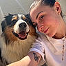 Vaïko a rejoint le concours — aidez-le/la à gagner de superbes lots ! woman, person, dog, pet, selfie, portrait, smiling, happy, outdoors, sunlight, fluffy, tricolor, long_hair, brown_eyes, earrings, tattoo, white_shirt, wall, closeup, animal_companion