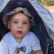 Gabriel a rejoint le concours — aidez-le/la à gagner de superbes lots ! baby, blanket, blue_eyes, bow_tie, child, curious, cute, daylight, hat, infant, outdoor, person, plaid, portrait, seat, stroller, sunlight, toy, white_shirt, young_child
