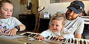 Lúccia a rejoint le concours — aidez-le/la à gagner de superbes lots ! baby, beard, casual_clothing, child, family, furniture, guitar, happy, hat, indoor, joy, keyboard, man, music, musical_instrument, person, photography, playing, room, smile