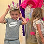 child, boy, girl, crown, nike, grey_clothing, leopard_print, indoor, smile, decorations, door, floor, happy, standing, person, young_child, casual_clothing, background, celebration, playful