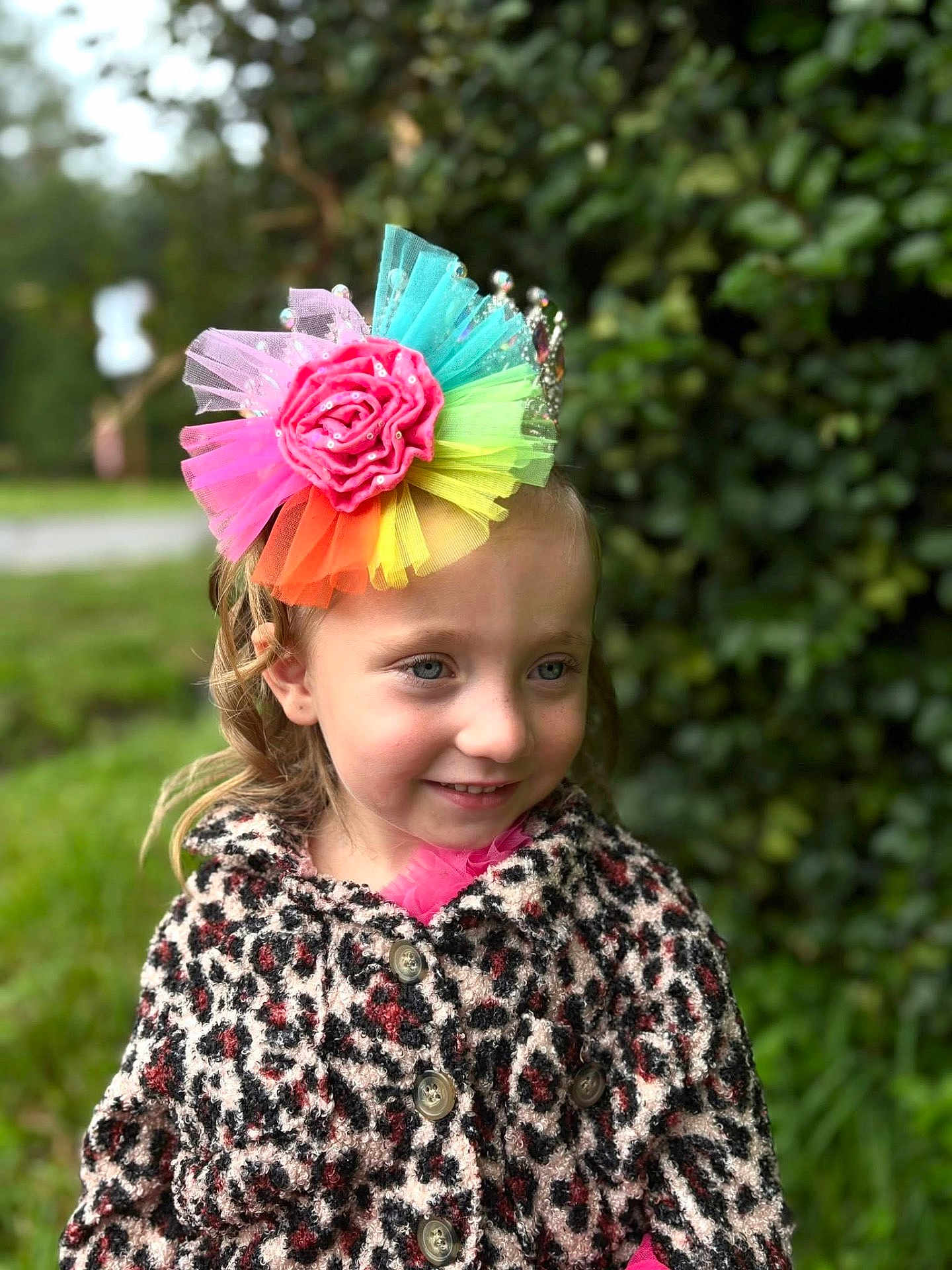 Valarie is registered to the contest to win money with this photo: child, girl, smile, outdoor, greenery, flower_headpiece, colorful, leopard_print, coat, portrait, happy, cute, fashion, nature, young, headwear, buttoned_coat, face, person, daylight
