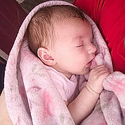Hazel is registered to the contest to win money with this photo: baby, blanket, sleeping, infant, person, hand, pink, soft, cozy, wrapped, newborn, face, skin, clothing, indoor, tender, holding, peaceful, human, portrait