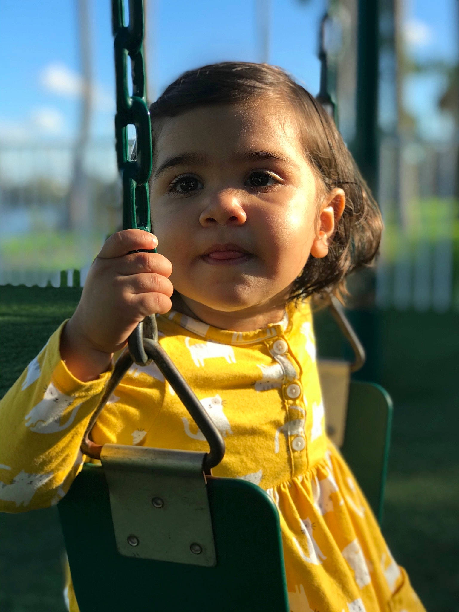 Olivia joined the competition — help win amazing prizes! child, outdoor_play_equipment, person, playground, smile, swing, toddler, yellow