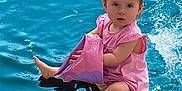 Arya participe au concours pour gagner de l'argent avec cette photo : toddler, child, pink_dress, water, pool, floatie, sitting, splash, summer, outdoor, cute, barefoot, playful, baby, young_child, water_toy, swimming, fun, sunlight, vacation