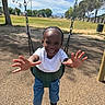 Kordae is registered to the contest to win money with this photo: child, swing, playground, park, smile, happy, outdoor, daylight, tree, grass, blue_sky, clothing, footwear, person, joy, reaching_hands, fun, activity, nature, leisure