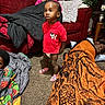 toddler, child, adult, blanket, carpet, sofa, living_room, red_clothing, mickey_mouse, socks, indoor, person, portrait, family, candid, furniture, relaxing, people, home, expression