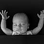 baby, sleeping, arms_up, blanket, black_and_white, portrait, peaceful, infant, closed_eyes, cute, soft_light, newborn, calm, face, skin, head, child, monochrome, rest, adorable
