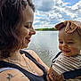 Meï participe au concours pour gagner de l'argent avec cette photo : woman, baby, smiling, outdoor, lake, water, cloudy_sky, headband, striped_clothing, tattoo, necklace, happy, portrait, nature, child, person, holding, greenery, daylight, casual