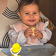 Giorgia a rejoint le concours — aidez-le/la à gagner de superbes lots ! baby, bib, high_chair, smile, food, snack, toy, indoor, child, happy, face, person, clothing, seat, furniture, cute, messy, hands, table, home