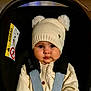 baby, child, car_seat, hat, pom_poms, knitwear, sweater, straps, face, eyes, chubby_cheeks, clothing, infant, seatbelt, warm_clothing, indoor, portrait, cute, childhood, baby_fashion